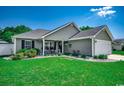 Charming single-story home featuring lush green lawn, landscaping, and inviting front porch with rocking chairs at 113 Adelphia Rd., Loris, SC 29569
