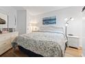 A bright bedroom featuring a queen-size bed with floral bedding, white dresser, and coastal-themed artwork at 1210 N Waccamaw Dr. # 305, Murrells Inlet, SC 29576