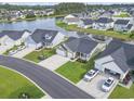 Aerial view of homes surrounding a serene lake in a well-manicured community at 122 New Paradise Way, Myrtle Beach, SC 29588