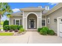 Inviting front entrance with an arched portico, complemented by tasteful landscaping at 131 Sago Palm Dr., Myrtle Beach, SC 29579