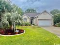 Inviting single-story home with mature landscaping, lush lawn, and ample driveway space for multiple cars at 1504 Saint Thomas Circle, Myrtle Beach, SC 29577