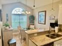 Inviting kitchen area with granite countertops, stainless steel sink and well lit dining area at 1504 Saint Thomas Circle, Myrtle Beach, SC 29577