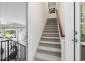 Carpeted staircase leading from the garage, with a wooden handrail and white trim at 160 Stonington Dr., Murrells Inlet, SC 29576