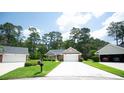 Charming home features a long driveway, lush green lawn, mature trees, and attached garage at 170 Glenwood Dr., Conway, SC 29526