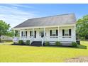 Inviting single-story home showcasing a classic white facade and a spacious front porch at 1763 Lipscomb Rd., Mullins, SC 29574