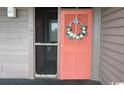 The front door entrance with screen door and decorative wreath at 206 2Nd Ave. N # 271, North Myrtle Beach, SC 29582