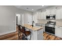 Modern kitchen features an island, white cabinetry, stainless appliances, and bar seating at 2505 Suzanne Dr., Conway, SC 29526