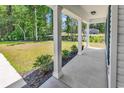 Inviting front porch with classic columns, complemented by lush greenery, offering a relaxing outdoor space at 255 Yauhanna Lake Dr., Georgetown, SC 29440