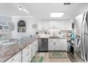 Bright kitchen boasts white cabinets, stainless steel appliances, granite countertops, and barstool seating at 307 74Th Ave. N # 3C, Myrtle Beach, SC 29572
