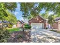 Charming brick home with a well-maintained lawn, lush landscaping, and a two-car garage at 3071 Alice Ln., Little River, SC 29566