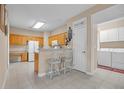 Bright kitchen boasts tile flooring, wooden cabinets, breakfast bar and adjacent laundry room at 3071 Alice Ln., Little River, SC 29566