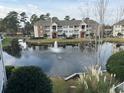 Scenic view of condo buildings overlooking a serene pond with a fountain feature at 3761 Citation Way # 531, Myrtle Beach, SC 29577