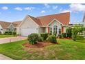 Charming single-story home with a well-manicured lawn and red painted driveway at 425 Mallard Lake Circle, Surfside Beach, SC 29575