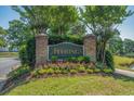 Community sign for The Moorings surrounded by flowers, greenery, and manicured lawn at 4450 Turtle Ln. # 2-A, Little River, SC 29566