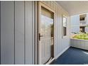 Cozy condo entrance features a screen door and wood-panel siding with a view of landscaping at 4520 Coquina Harbour Dr. # F-3, Little River, SC 29566