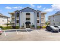 Charming condo building with classic design, well-kept landscaping, and ample parking space for residents and guests at 4520 Coquina Harbour Dr. # F-3, Little River, SC 29566