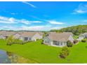 Spacious backyard with lush greenery, screened porch, and pond views at 5 Coffee Mill Creek Ln., Carolina Shores, NC 28467