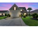 Charming home featuring a well-manicured lawn and a spacious driveway at twilight, creating a cozy ambiance at 5146 Fairmont Ln., Myrtle Beach, SC 29579