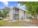 Condo back exterior showing screened porch, neutral siding, well-maintained lawn and mature trees at 5406 Sweetwater Blvd. # 5406, Murrells Inlet, SC 29576
