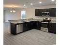 Modern kitchen featuring stainless steel appliances, granite countertops, and stylish black cabinetry at 5408 Hampton Rd., Conway, SC 29527