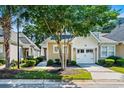 Beautiful tan home with a front yard, bushes, and a 1 car garage at 6244 Catalina Dr. # 511, North Myrtle Beach, SC 29582