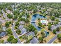 Beautiful aerial showcasing homes by a pond and community pool surrounded by trees at 67 Camden Circle, Pawleys Island, SC 29585
