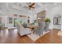 Comfortable living room featuring a stone fireplace, wood floors, coffered ceilings, and plenty of natural light at 7202 Seville Dr., Myrtle Beach, SC 29572
