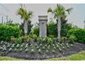 The Sanctuary community entrance features lush landscaping, palm trees, and seasonal flowers at 1141 Prescott Circle, Myrtle Beach, SC 29577
