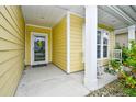 Inviting front porch with yellow siding, a welcome mat, and a decorative door at 1141 Prescott Circle, Myrtle Beach, SC 29577