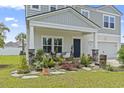 Inviting front porch with beautiful landscaping and cozy seating area perfect for relaxation at 205 Marsh Deer Place, Surfside Beach, SC 29575