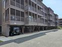 The exterior of the condo shows elevated construction with screened balconies and ground level parking at 207 N 3Rd Ave. N # 247, North Myrtle Beach, SC 29582