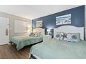 Comfortable bedroom featuring two beds, stylish decor, and calming blue accent wall at 208 74Th Ave. N # 2-417, Myrtle Beach, SC 29572