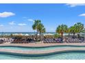 Resort pool area with palm trees, lounge chairs, and a beautiful beach view at 3000 N Ocean Blvd. N # 129, Myrtle Beach, SC 29577
