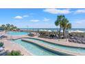 Resort pool area with lush palm trees, lounge chairs, and a beach view in the background at 3000 N Ocean Blvd. N # 129, Myrtle Beach, SC 29577