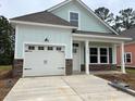Charming single-Gathering home with a white garage door, stone accents, and light blue siding at 3129 Tiger Tail Rd., Conway, SC 29526