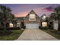 Charming two-story home with brick facade, manicured lawn, and two-car garage against a sunset sky at 3210 Volterra Way # 3210, Myrtle Beach, SC 29579