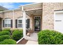 Inviting front porch with a bench and decorative shrubs highlighting the brick facade at 3210 Volterra Way # 3210, Myrtle Beach, SC 29579