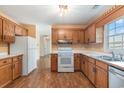 Functional kitchen with oak cabinetry, white appliances, and a stainless steel sink at 3429 Mishoe St., Loris, SC 29569