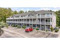 Condo building featuring multi-level balconies, well-manicured landscaping, and convenient parking at 4506 West Harbor Ct. # U-15, Little River, SC 29566