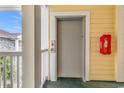 Hallway with elevator door and fire extinguisher on the wall with yellow wood-look exterior at 4705 Wild Iris Dr. # 305, Myrtle Beach, SC 29577