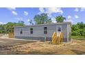 Rear exterior view of a home featuring a wooden porch and convenient access stairs at 491 N Green Sea Rd., Loris, SC 29569