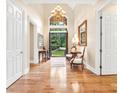 Bright foyer with hardwood floors, chandelier, and a glimpse of the landscaped yard through the front door at 509 Heston Point Dr., Pawleys Island, SC 29585