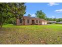 Traditional brick home with a well-manicured lawn, American flag, and attached two-car garage at 5206 Columbia St., Conway, SC 29526