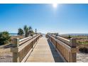 Inviting wooden boardwalk leads to a beautiful beach with clear blue skies and ocean views at 5523 North Ocean Blvd. # 1903, Myrtle Beach, SC 29577