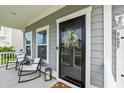 Inviting covered porch featuring rocking chairs, a lantern, and a black front door with decorative wreath at 5605 Whitebark Dr., Myrtle Beach, SC 29577