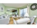 Comfortable living room with sliders to the balcony, featuring light green walls, neutral furniture, and a flat-screen TV at 5905 South Kings Hwy. # 116B, Myrtle Beach, SC 29575