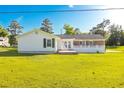 View of the back of the house with a patio and a spacious backyard, perfect for outdoor entertaining at 64 Highway 521, Andrews, SC 29510