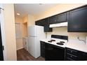 Efficient kitchen area with white appliances, dark cabinetry and a laundry area at 669 Tupelo Ln. # 18D, Longs, SC 29568