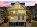 Stylish elevated home with a private balcony and pool offers stunning coastal living with beach proximity at 703 S Waccamaw Dr., Garden City Beach, SC 29576