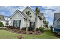 Charming home featuring attractive landscaping with colorful flowering plants and small palm trees at 7040 Belancino Blvd., Myrtle Beach, SC 29572